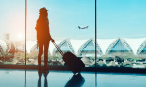 Silhouette,Woman,Travel,With,Luggage,Looking,Without,Window,At,Airport
